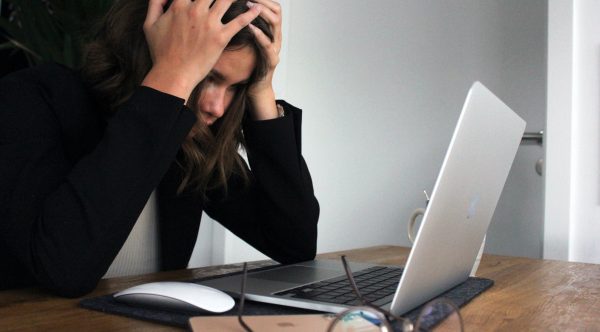 Eine Frau gestresst von ihrem Laptop.