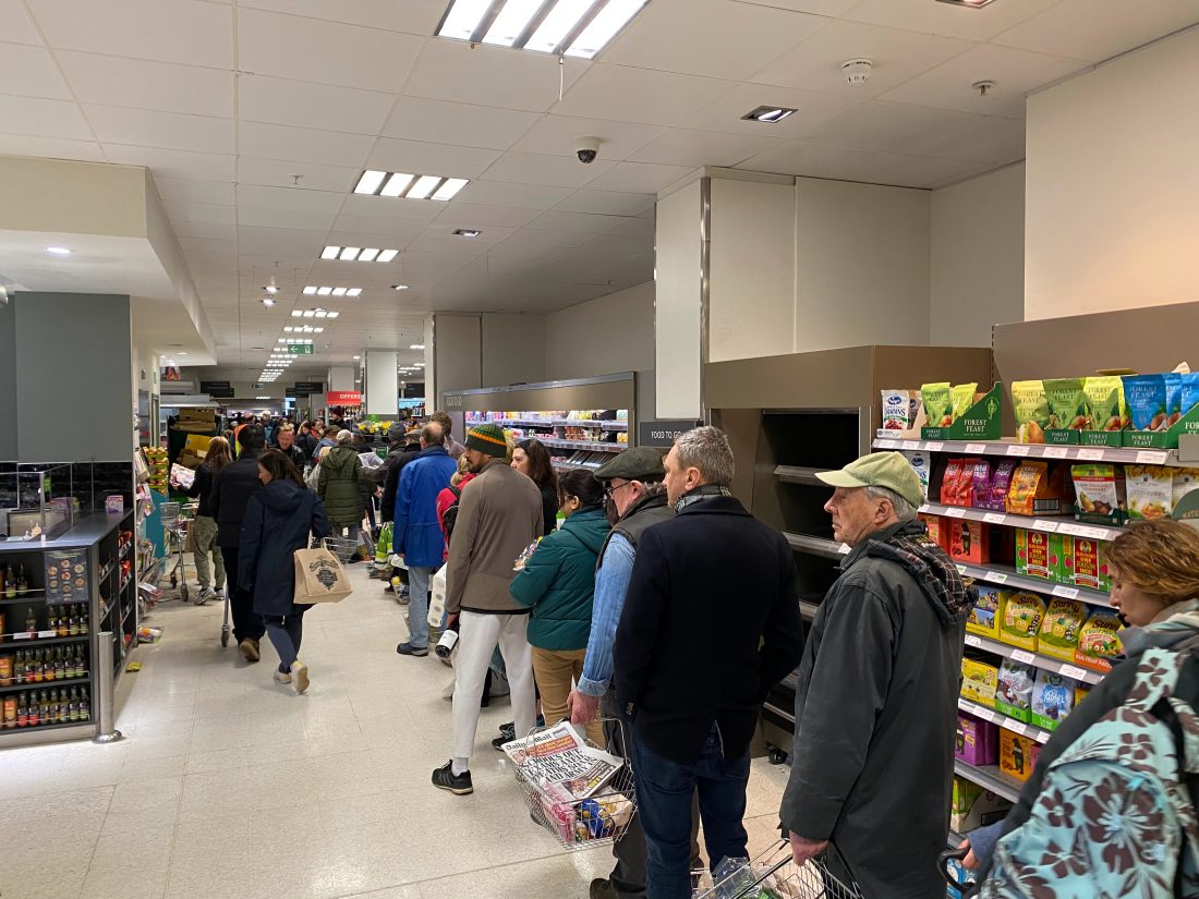 Menschen stehen in einer Schlange beim Einkaufen.