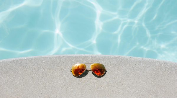 Eine verspiegelte Sonnenbrille am Pool.
